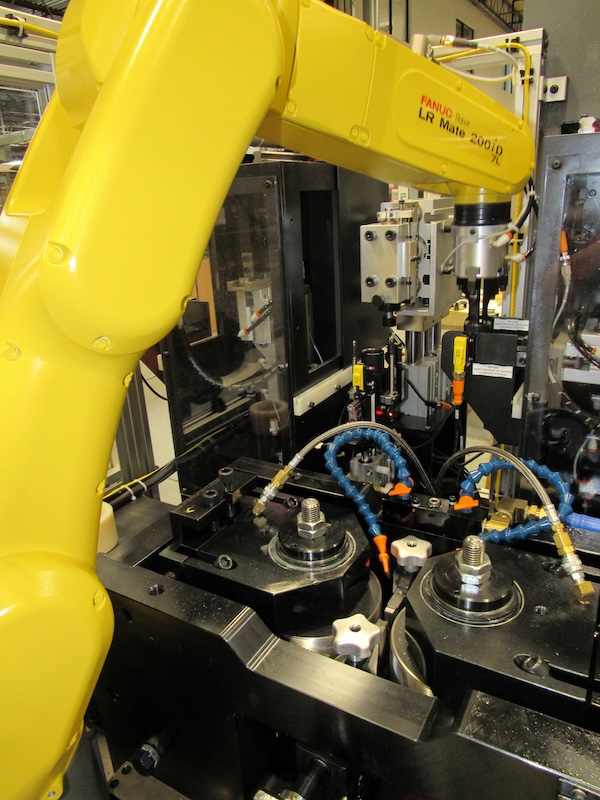 A yellow robotic arm brings automation to the Kinefac machine.